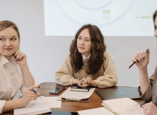 3 Young Professional Women Sitting Around a Conference Table